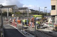 Tram rails being laid through Haymarket Yards on 20 September, along the curving route between the office blocks. A 334 unit passes by on the E&G main line in the background.<br><br>[Bill Roberton 20/09/2011]