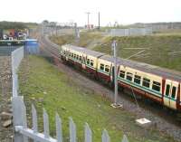 The 11.21 ex-Edinburgh Waverley has just left the Armadale stop and passed below Station Road on its way to Helensburgh Central on 19 September. The train is running through an area on which considerable preparatory work (not least additional drainage) was required during the construction phase [see image 26594]. It will shortly pass the site of the original Armadale station (of which nothing remains) opened by the Bathgate and Coatbridge Railway in 1862 and closed in January 1956. A new housing development is currently underway beyond the fence in the right background.<br>
<br><br>[John Furnevel 19/09/2011]