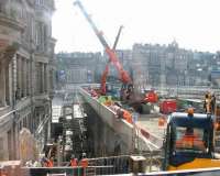 View south from Princes Street over the temporary wooden hoardings, showing work progressing beyond on Waverley Steps on 27 September 2011. The Balmoral Hotel stands on the left, with Princes Mall (through which a temporary entrance to the station has been provided) on the right. [See image 41372] (With thanks to the driver of the 37 bus).<br><br>[John Furnevel 27/09/2011]