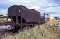 In 1974, rail was still hanging on to a worthwhile share of the whisky-related transport market within Scotland, either via modernised railheads serving wider catchments or directly to surviving private sidings at a few of the biggest distilleries and bottling plants. Virtually the whole portfolio of what rail could offer at that time is seen here in Invergordon goods yard - a (grubby) hopper wagon which had brought grain to the nearby distillery sidings and would return south with waste product used for animal feed; an equally tarnished early-generation container for southbound casks of whisky; and, in the distance, a splendidly clean 'Cutty Sark' tank container for bulk spirit.<br>
<br><br>[David Spaven //1974]