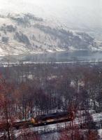 An unknown 37 (with nameplate) heads south with a PW train by the north end of Loch Lomond in 1991.<br><br>
<br><br>
In the background the precursor to the railway can be seen. The River Falloch, to the left, flows into the head of the loch. In 1847 this portion of the River Falloch was canalised as far north as the Inverarnan Inn. Steamers operated to a pier there, coming north from Balloch via various piers and connecting with coaches which ran north to Fort William and Killin.<br><br>[Ewan Crawford //1991]