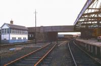 Looking along the through platform at Elgin East in August 1987 as a class 47 passes below the A941 road bridge with an Aberdeen - Inverness train. <br><br>[Ian Dinmore /08/1987]