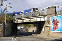 An inbound class 380 on an East Lothian - Edinburgh service crosses Spring Gardens, near Abbeyhill on 11 October. In the background a class 91 features on an East Coast advertisement.<br><br>[Bill Roberton 11/10/2011]