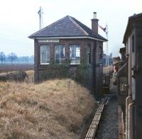 Bridge of Earn signalbox is the focus of attention for the camera toting members of the EURS party as the afternoon Millerhill to Inverness freight passes on the line from Ladybank on 3 March 1971. The disused double track of the Glenfarg line, closed some fourteen months previously can be glimpsed between the box and train. <br>
<br><br>[Bill Jamieson 03/03/1971]
