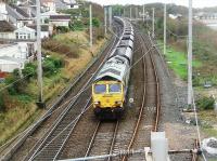 Freightliner's 66507 powers north alongside Morecambe Bay with empty coal hoppers bound for Scotland. It was interesting to see, from the high footbridge, the insides of the tall wagons and just how battered the internal vanes are that separate the hoppers. The shiny, well used main line rails here contrast with the lightly used link to Bare Lane on the right.<br><br>[Mark Bartlett 10/10/2011]