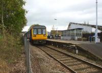 Looking towards the buffers at Colne with a Class 142 waiting to head west back to Blackpool on 21 October 2011. The fence line is running along what would have been the 4 foot of the Skipton bound platform. The platform edge is still there although the trees have taken a firm hold dislodging some of the slabs. [See image 33639] taken 34 years ago before the old platform had been landscaped.<br>
<br><br>[John McIntyre 21/10/2011]