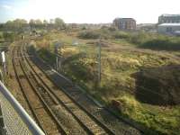 View from a footbridge looking south east towards Nuneaton station with Abbey Junction and Birmingham behind the camera. The lines just off picture to the right (between excavator and new flats) cross the flyover over the WCML and run into platforms 6 and 7 on the east side of the station [see image 32902]. The new Nuneaton North Chord, on which work has recently commenced, will provide a link between this line and the northbound WCML off picture to the left. This will allow rail traffic coming off the flyover to join the down WCML without the need to cross the up main line at the south end of the station as at present. Before joining the WCML the new chord will pass over the existing link between Abbey Junction and Nuneaton North Junction. Note vegetation clearance in progress.<br><br>[Ken Strachan 22/10/2011]