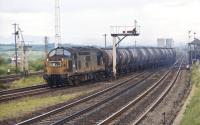 A very grubby English Electric Type 3 No. 6838 and its short train of 45T oil tanks veers right at Greenhill Lower Junction in June 1971. The train will have originated at Grangemouth and could be for a number of destinations in the West of Scotland.<br><br>[Bill Jamieson 16/06/1971]