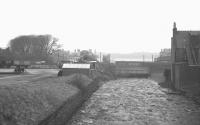 A Sunday evening at Largs in the summer of 1962. View is west with the Isle of Cumbrae in the background. Trains are standing at the platforms of Largs station in the centre of the picture, while on the left is part of the former goods yard. The latter is now occupied by a supermarket and its associated car park.<br><br>[R Sillitto/A Renfrew Collection (Courtesy Bruce McCartney) /07/1962]