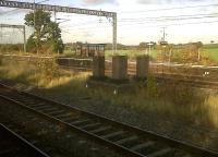 The concrete supports are are all that remains of the footbridge at this Trent Valley station (the cost of a replacement could not be justified). So the station's only train, the 07.26 weekday service to Crewe, has no 'parliamentary' equivalent service heading South. The 'Way Out' sign pointing skyward from the abandoned platform is at least as poignant as the rusty 'bus shelter'. [Additional: In its <i>West Midlands Route Utilisation Strategy</i> (2005) the Strategic Rail Authority called for Polesworth station to be closed, noting that each train that calls there receives on average less than one passenger!]<br><br>[Ken Strachan 04/11/2011]