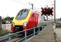 A Virgin Trains Manchester - Birmingham - Brighton service photographed on the level crossing 50 yards north of Mitre Bridge Junction in July 2005. Immediately after passing through the junction the train will cross the Grand Union Canal [see image 4921] and run south east to Clapham Junction on the West London Line, at which point it will turn south towards Brighton. <br><br>[John Furnevel 22/07/2005]