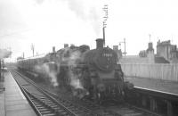 77017 with a Kilmarnock - Ardrossan (Winton Pier) train arriving through the rain at Irvine on 25 May 1963. The Standard class 3 2-6-0 had been sent to 67B Hurlford new from Swindon Works in 1954 and remained there until withdrawal in 1966.<br><br>[R Sillitto/A Renfrew Collection (Courtesy Bruce McCartney) 25/05/1963]