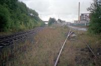 Dalnottar Oil Depot at Old Kilpatrick and the Arnott Young scrapyard was the furthest west extent of the former Lanarkshire and Dumbartonshire Railway line from Clydebank between the 1960s and 1980s (with the obvious exception of the portion still in use today between Dunglass Siding at Bowling and Dumbarton Central). This 1987 view looks east with the former mainline to the left and Dalnottar Oil terminal siding to the right. By this date both lines were lifted behind the camera. The Arnott Young scrapyard by Erskine Ferry Road was already demolished and landscaped although a level crossing remained and can be seen to this day. [See image 36639 for a present day equivalent to this view.]<br><br>[Ewan Crawford //1987]