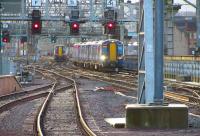 View through the arch at the end of platforms 12 & 13 on 2 September as 380009 arrives from Gourock while 380017 on the left sets out on the reverse trip under clear signals.<br><br>[John McIntyre 02/09/2011]