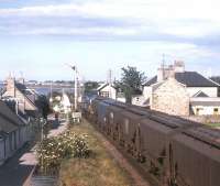 A Class 40 eases the regular Muir of Ord to Doncaster empty grain train across the Caledonian Canal at Clachnaharry in the 1970s. This was one of the first dedicated trainload (as opposed to mixed freight) workings in the Highlands - beginning in the mid-1960s - with barley from the East of England aggregated into a full train at Doncaster, working up the ECML to Aberdeen. North of Aberdeen, the alternate destinations were the Burghead maltings private siding and a rail-connected silo at Muir of Ord feeding the maltings on the edge of the village. [See image 24214]<br><br>[Frank Spaven Collection (Courtesy David Spaven) //]