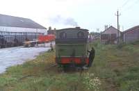 <I>'There's track down there somewhere...'</I>. During the short period when the Derwent Valley Light Railway hosted steam passenger services J72 0-6-0T 69023 <I>Joem</I> runs round its train at Dunnington in 1978. At this time the line was still being used for freight services, hence the covered hopper wagons in the sidings. Weedkilling does not appear to have been a priority. [See image 26977]<br><br>[Mark Bartlett //1978]