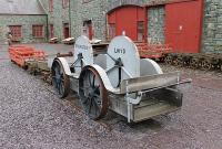 A curious rail vehicle to say the least. The <I>Malwoden Lwyd</I> or <I>Grey Snail</I>, an eight seater velocipede with hand crank power at every seat. Used for transporting Dinorwic Quarry workers along the 4' gauge Padarn Railway and now preserved at the National Slate Museum of Wales, which is in the old quarry workshops. Behind are a number of very old, double flanged trucks formerly used in various parts of the local quarry system.  <br><br>[Mark Bartlett 02/12/2011]