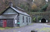 The old Padarn Railway engine shed, which for many years housed <I>Fire Queen</I>, the preserved 1848 locomotive from that railway. <I>Fire Queen</I> was removed in 1969 when the quarry closed and is now displayed at Penrhyn Castle Railway Museum but the shed is now part of the Slate Museum complex as is the disused tunnel. Just behind the camera the tracks of the Llanberis Lake Railway swing away from the old Padarn formation to head into Llanberis village. <br><br>[Mark Bartlett //]