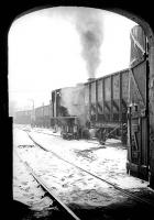 Peeking out of Backworth NCB shed, Northumberland, as one of the austerity 0-6-0STs shunts in the snow in December 1974.<br><br>[Bill Roberton /12/1974]