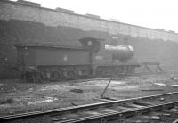 A damp and misty morning on Bolton shed, featuring ex-Lancashire & Yorkshire 0-6-0 no 52523. The locomotive, of 1909 vintage, had been withdrawn in September 1962 and is seen here having been 'stored' at the end of a siding. The photograph is thought to have been taken during a visit on 29 June 1963 (although there is some conflict with reported disposal dates).<br><br>[K A Gray 29/06/1963]