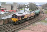 EWS liveried 66107 runs alongside Union Road, Grangemouth, on 20 December 2011 with empty tanks returning to the refinery. The train is about to pass below the bridge carrying the A904 Station Road and is a short distance from its ultimate destination.   <br><br>[John Furnevel 20/12/2011]