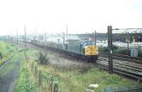 A location that has hardly changed since the 1972 WCML electrification, but which made the national headlines in December 2011 when a large fire on the business park seen here closed the line completely for several hours. In August 1980 40030 (formerly <I>Scythia</I>) snakes across from the Down Slow to take a northbound freight onto the East Lancashire line to Blackburn, from where it will probably head for the S&C via Hellifield. 40030 lasted in service until withdrawn from Longsight in April 1983 being cut up one year later at Crewe Works.<br><br>[Mark Bartlett 29/08/1980]