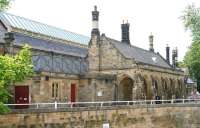 Looking south west towards the multi-arched main entrance to the 1846 Tudor style station building at Richmond, North Yorkshire, in June 2011. Located at the end of a branch off the ECML at Eryholme Junction, south of Darlington, Richmond closed to passengers in March 1968. Following an unsuccessful spell as a garden centre the building has now been refurbished and put to use as a thriving visitor and community centre [see image 35115].<br><br>[John Furnevel 27/06/2011]