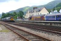 A morning train from Glasgow running into platform 1 at Fort William station on 28 June 2010 with the Caledonian Sleeper stabled in platform 2.<br><br>[Colin Miller 28/06/2010]