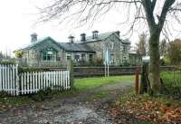 Entrance to the former goods yard at Wensley, in the Yorkshire Dales, in November 2004. View is south across what is now the Wesleydale Railway's line between Leeming and Redmire, with the closed Wensley station standing beyond and the level crossing just off picture to the left. The station, closed in 1954, has since been converted to holiday accommodation. [See image 1589].<br><br>[John Furnevel 05/11/2004]