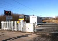 Glasgow bound 320314 passes what was once Ardmore West level crossing on 1 March 2010. Since my previous visit to the site [see image 15297] the base of the old SB has been replaced by this building and the user worked gates replaced by automatic half barriers. The location is also now known as Moss Road AHB.<br><br>[John McIntyre 01/03/2010]