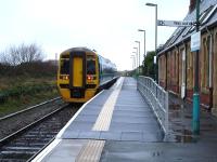 158821 departs Aberdovey on 6 December with the 10.09 ex Birmingham International service to Pwllheli, with the short low cost raised platform structure visible.<br><br>[David Pesterfield 06/12/2011]