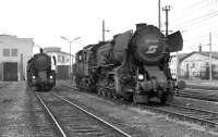 This pair of Krieglok 2-10-0s standing on Linz MPD show the difference in appearance brought about by the fitting of a Giesl ejector. 52 3816 on the left is so fitted while 52 4364 on the right has the original exhaust arrangement, albeit its 'face' has been altered by the fitting of a feedwater heater in the smokebox, the casing for which is visible in front of the chimney. It is also unusual in displaying the then current BB logo on its smokebox door - the only loco so adorned which I photographed on this trip. <br><br>[Bill Jamieson 26/08/1974]