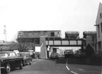 BRCW 'Crompton' Type 3 no D6575 of Hither Green shed threads the back streets of NW10 between Mitre Bridge Junction and Willesden Junction High Level station in March 1969. The train of Presflos is on the spur linking the West London and North London lines. (Note: D6575 {later class 33 no 33057} was withdrawn in August 2005 and subsequently purchased for preservation. The locomotive is currently undergoing refurbishment on the West Somerset Railway.) [See image 40259]<br><br>[John Furnevel 18/03/1969]