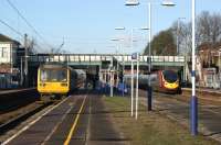 The tortoise and the hare ...or perhaps the donkey and the racehorse? On the left the 14.09 service to Liverpool Lime Street gets underway from Leyland, just as the 13.59 from Preston to Euston passes at speed on 6 February 2012. Meanwhile, on the platform, the men in orange have returned to erect the new shelters. <br><br>[John McIntyre 06/02/2012]