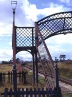 Looking through the remains of the redundant station footbridge at Fearn as a Class 26 hauled northbound freight approaches in the summer of 1974. [With thanks to all who responded to this query]<br><br>[David Spaven //1974]