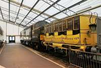 <I> Ancient and relatively modern</I>. Prototype English Electric Type 3 D6700, which has now passed its 50th birthday, poses in a temporary annex building at the NRM York. Buffered up to the Class 37 is a replica Liverpool and Manchester Railway coach, the original of which would now be around 180 years old, and they make an interesting comparison. A link between these two vehicles is that the L&M Rly passed through Earlestown where D6700 was built at EE's Vulcan Foundry. <br><br>[Mark Bartlett 02/02/2012]