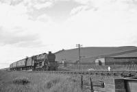 Ardrossan's Black 5 no 45479 approaching the town from the north in early July 1962. The train is passing the site of the former Montfode fuel depot, built during WW II to store aviation fuel produced at the nearby Shell refinery for use by the RAF [see image 25001]. The facility was rail served and included 5 large underground storage tanks.<br><br>[R Sillitto/A Renfrew Collection (Courtesy Bruce McCartney) 03/07/1962]