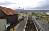 Looking north from the footbridge at Brora as a southbound pair of Class 156 DMUs waits to pass a northbound service in August 1989. A crew change will take place here and the driver is walking towards the end of the northbound platform to await his train.<br><br>[John McIntyre 15/08/1989]