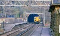 A Trans-Pennine DMU exits Woodhead Tunnel, westbound, in February 1981 and is about to run through the platforms of the closed Woodhead station.<br><br>[Peter Todd /02/1981]