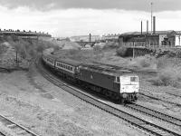 A morning Harrogate - Kings Cross express, hauled by 47521, rounds the tight curve on the approach to Wortley Junction, Leeds, on 30 April 1977. The trackwork in the area has obviously been severely rationalised but recently enough that the usual birch forest has not had time to establish.<br><br>[Bill Jamieson 30/04/1977]