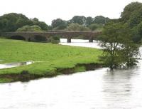 High water on the Nith at Dumfries looking north in September 2009 following a period of heavy rain which resulted in local flooding. In the background is the bridge that carried the Port Road across the river on its journey to Stranraer, with the short section serving the former ICI Works at Cargenbridge, finally closing in 1994. The bridge is now the <I>Queen of the South Viaduct</I>, part of the 'Maxwelltown Railway Path' [see image 25379].<br><br>[John Furnevel 01/09/2009]