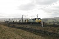 Ayrshire bound coal empties are lifted up the 1:75 Shap bank at Scout Green by Freightliner 70002. The next loco up the hill was 70013, but from a different class and era.<br><br>[Mark Bartlett 25/02/2012]