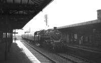 A wet and overcast day at Irvine station in May 1963. A Kilmarnock - Ardrossan (Winton Pier) train has just arrived at the northbound platform behind Hurlford shed's Standard class 3 2-6-0 no 77017.<br><br>[R Sillitto/A Renfrew Collection (Courtesy Bruce McCartney) 25/05/1963]