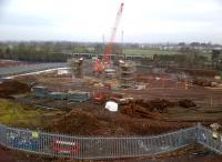 The snow has gone, and the piers of what will become the North Chord bridge over Stoney Road, Nuneaton, are steadily growing as a South-bound 350 passes on the WCML in the background.<br><br>[Ken Strachan 12/02/2012]