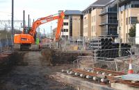 View west alongside the Edinburgh and Glasgow main line on 6 March 2012. On the right is the lower end of the Haymarket Yards tram tracks with more being laid in the distance. Offices now occupy the former coal yard.<br><br>[Bill Roberton 06/03/2012]