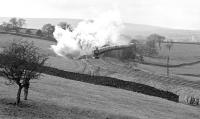 Preserved K1 No. (6)2005 and Black 5 No. 5407 are producing copious quantities of steam on a cold and unpleasant day as they approach the summit of the 'Little North Western' just east of Eldroth with the Carnforth to Hellifield leg of the <i>Cumbrian Mountain Pullman</i> on 5th February 1983. The train would continue north from Hellifield in deteriorating conditions behind Midland Compound 1000 and 5690 'Leander' only to be terminated at Appleby due to an incident on the WCML which resulted in the S&C being required as a diversionary route. Participants returned south by service train. [With thanks to Messrs Smith, Webb, Greig, Butterworth and Morgan])<br><br>[Bill Jamieson 05/02/1983]