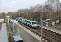 To the Altrincham line's supporters the letters MSJ&AR stood for <I>Many Short Journeys and Absolute Reliability</I>. It has fared pretty well under Metrolink too with a six minute frequency service the norm for some twenty years now. Tram 2001 draws to a halt at Timperley station on an Altrincham service. The platform on the left backs onto the Bridgewater Canal.<br><br>[Mark Bartlett 08/03/2012]