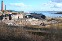 The formerly rail-served Caldwells/Inveresk Paper Mill at Inverkeithing succumbs to demolition after years of arson and scrap theft. At the extreme right, beyond the roadway, is a heap of rubble which was once the loco shed. Seen from a passing train on 5 March 2012.<br><br>[Bill Roberton 05/03/2012]