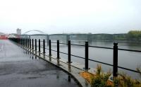 <I>What a grey day...</I> View east along the Tyne at Scotswood on a wet Sunday morning in May 2006. The 700ft long Scotswood rail bridge crosses the river in the middle distance with the steel arch of the road bridge visible beyond. The rail bridge, the fourth on this site, dates from 1871. It once brought the Newcastle and Carlisle Railway from Blaydon into Newcastle via the north bank of the River Tyne. Closure took place in 1982. The bridge now carries water and gas mains. [See image 9338]<br><br>[John Furnevel 07/05/2006]