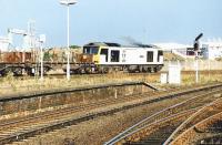 Transrail 60058 <I>John Howard</I> takes the station avoiding line at Middlesbrough on a hot August day in 1997 as it heads east with a train of steel flats. On the right is part of the Middlesbrough FC Riverside Stadium, opened 2 years earlier.<br><br>[John Furnevel 04/08/1997]